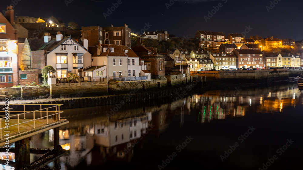 Lights of Whitby reflecting on the water at night.