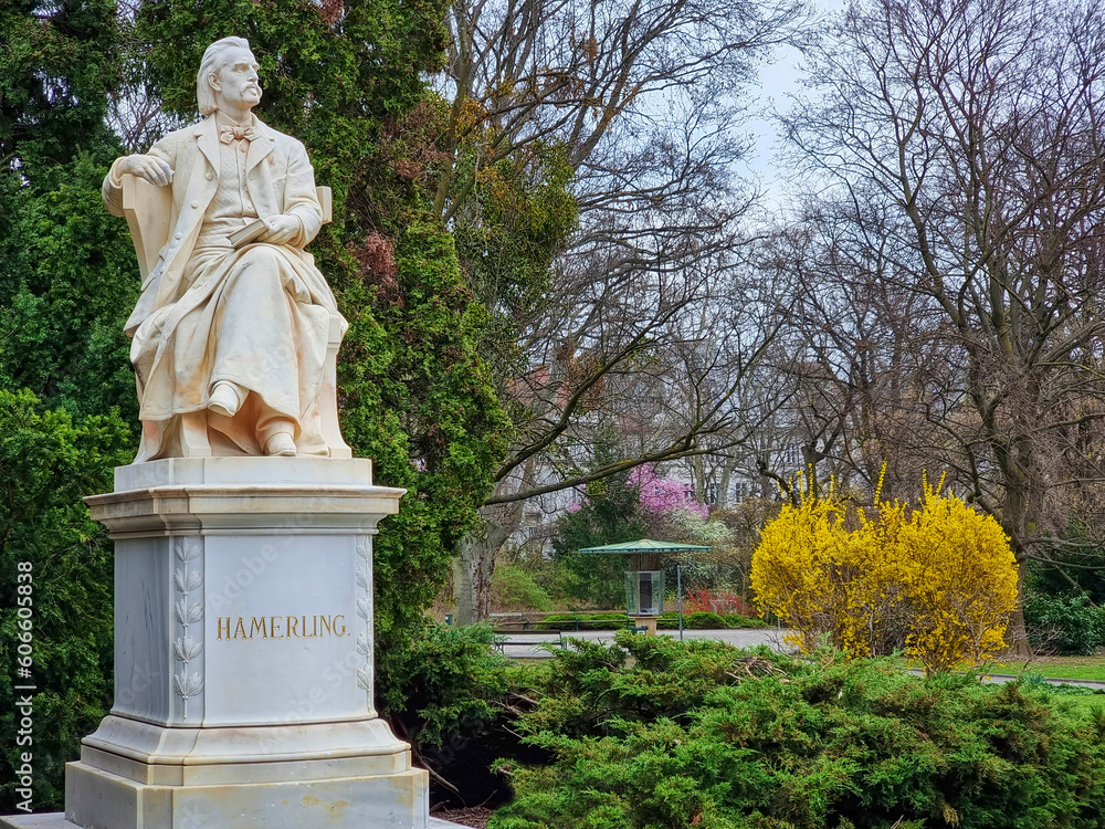 Marble statue of the austrian poet and writer Robert Hamerling sitting in a chair in the city park Stadtpark, in Graz, Steiermark region, Austria. Selective focus