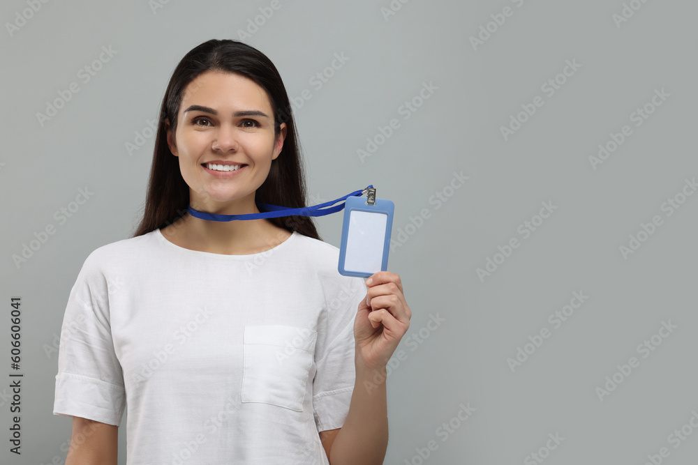 Happy woman holding vip pass badge on grey background, space for text Happy woman holding vip pass badge on grey background, space for text