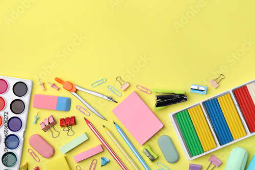 Flat lay composition with different school stationery on pale yellow background, space for text. Back to school