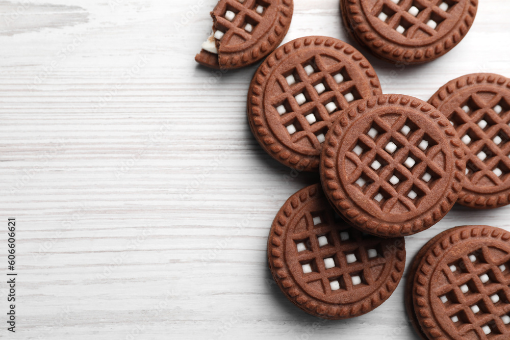 Tasty chocolate sandwich cookies with cream on white wooden table, flat lay. Space for text Tasty chocolate sandwich cookies with cream on white wooden table, flat lay. Space for text