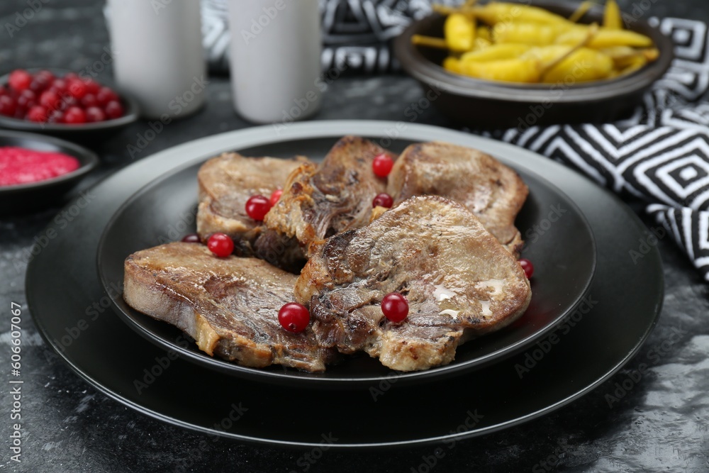 Tasty beef tongue pieces on dark table, closeup