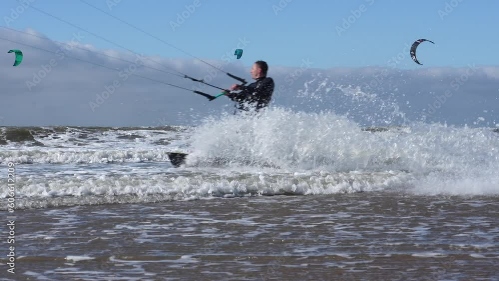 Many people enjoy riding kite surf board in windy day at sea ocean shore kitesurfing the Hague beacht. Watersport adrenaline fun adventure acitivity Many people enjoy riding kite surf board in windy day at sea ocean shore kitesurfing the Hague beacht. Watersport adrenaline fun adventure acitivity