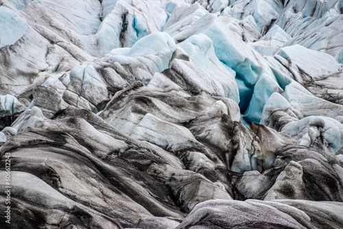 Glacier erosions in Iceland with black volcanic dust on the ice