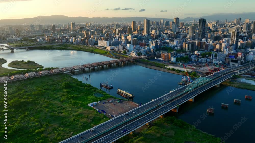 Osaka city aerial view, flying above river in downtown Osaka at sunrise with modern skyscrapers, Asian metropolis skyline Osaka city aerial view, flying above river in downtown Osaka at sunrise with modern skyscrapers, Asian metropolis skyline
