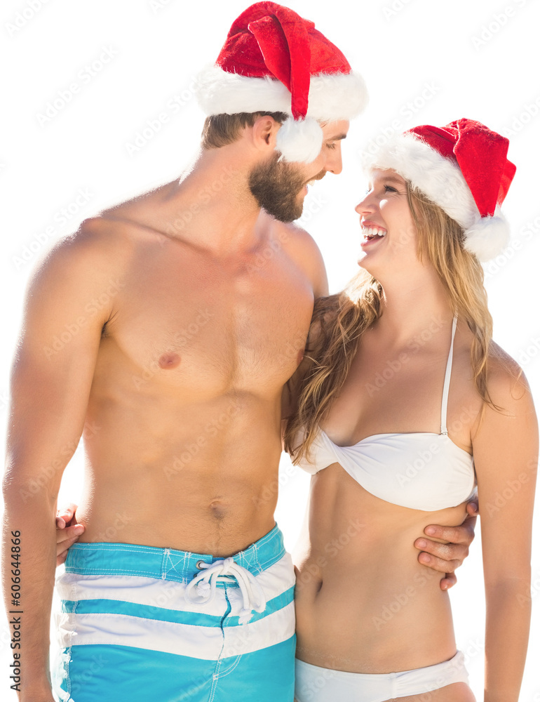 Digital png photo of smiling caucasian couple in santa hats and swimwear on transparent background Digital png photo of smiling caucasian couple in santa hats and swimwear on transparent background