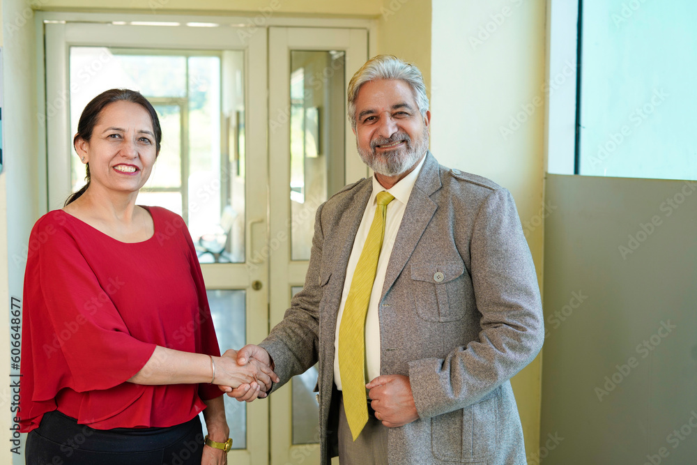 Senior businessman shake hand with female colleague. Senior businessman shake hand with female colleague.