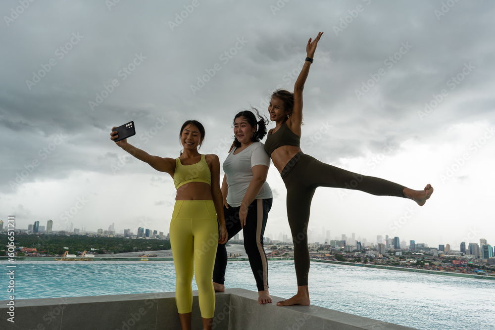 Φωτογραφία Friends having fun at swimming pool on skycraper roof top Selfie photo after finish yoga meditates against modern skyscrapers with swimming pool