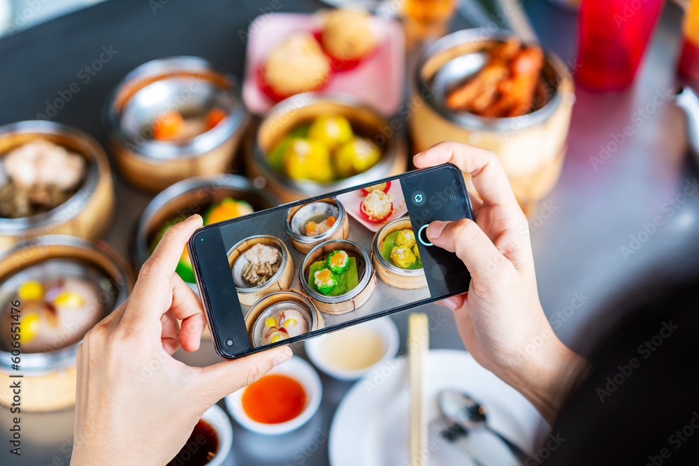 Φωτογραφία Young woman traveler taking a photo of  traditional Chinese Dim Sum at restauran