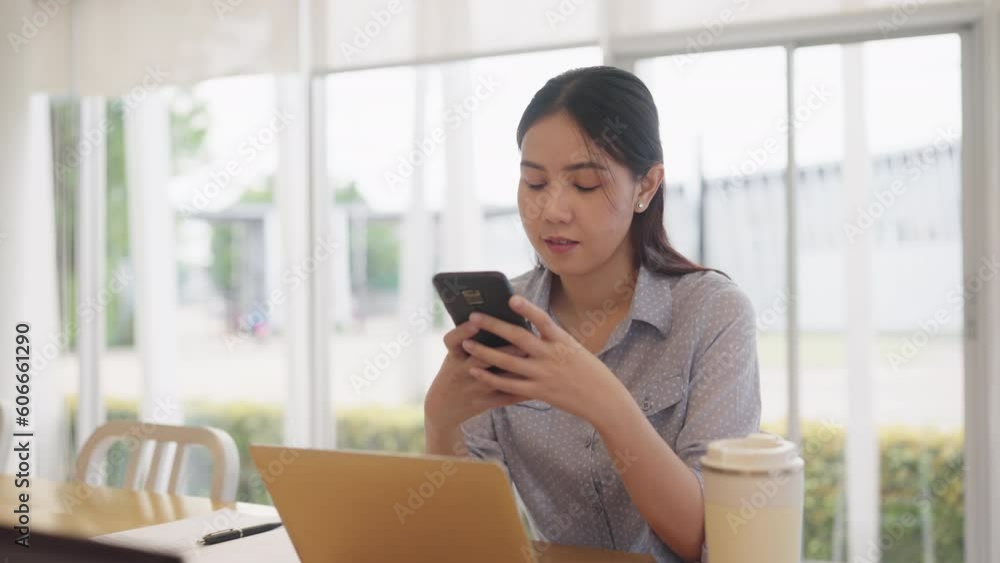 Adult female worker asia people happy smile sit easy relax work hybrid at share office enjoy play typing chat look at mobile phone buy or paying SME retail loan, post read news review app AI chatbot.