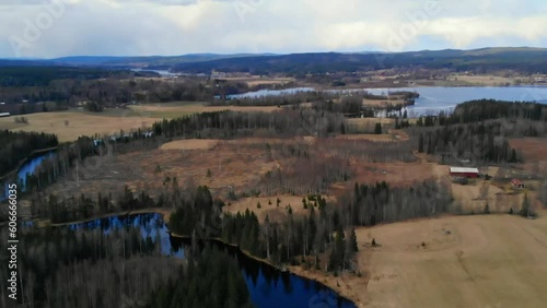 Drone shot tilting up with view over river, fields and lake in Sweden at fall. photo