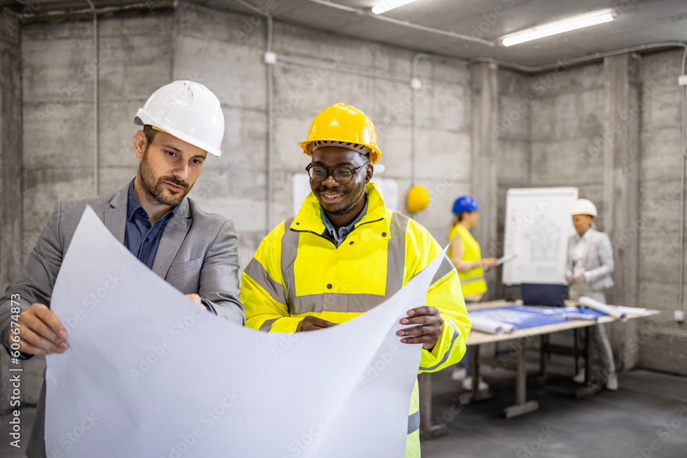 Architect and structural engineer discussing about next phase of building at construction site. Architect and structural engineer discussing about next phase of building at construction site.