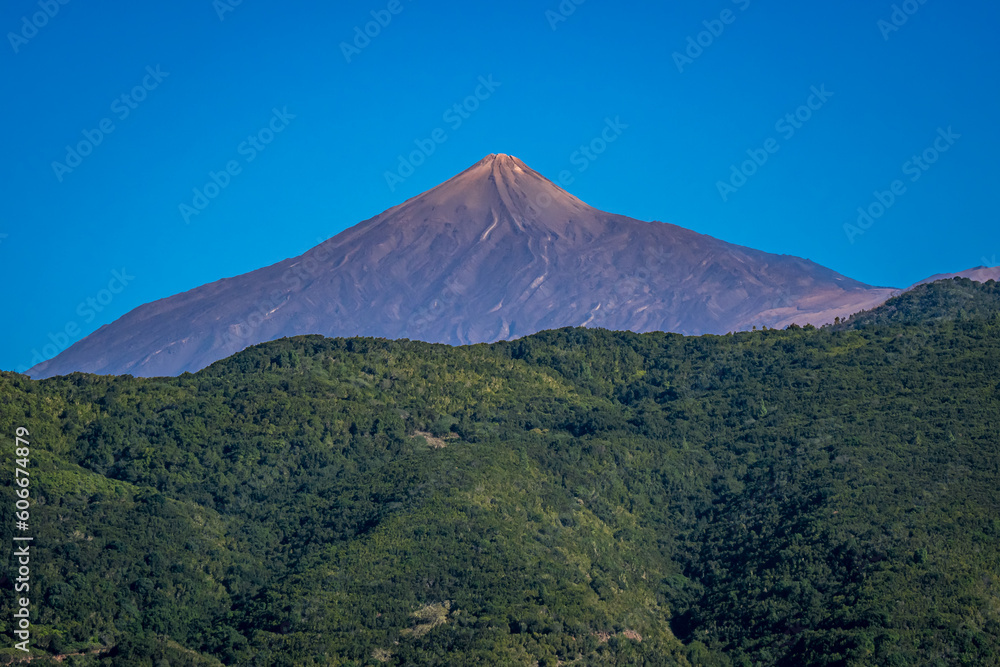 Grandeur of Teide volcano as the peak of Pico del Teide majestically rises above the lush green Teno mountains, offering a view that embark nature lovers on a journey to Teide National Park Tenerife.