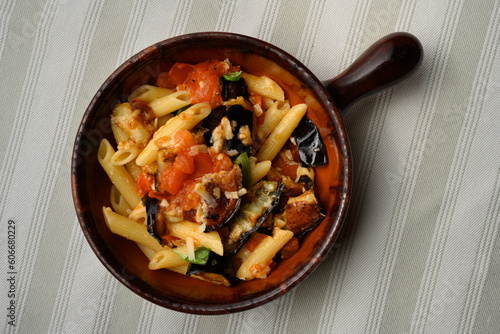 Pasta alla Norma or Penne Rigate with Eggplant and Tomato Sauce and Ricotta in a Rustic Terracotta Bowl photo