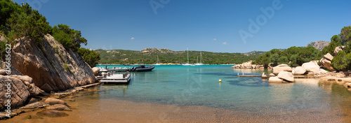 A panorama of the bay with yachts in Costa Smeralda, Italy. Turquoise transparent waters, rocks and a clear blue sky