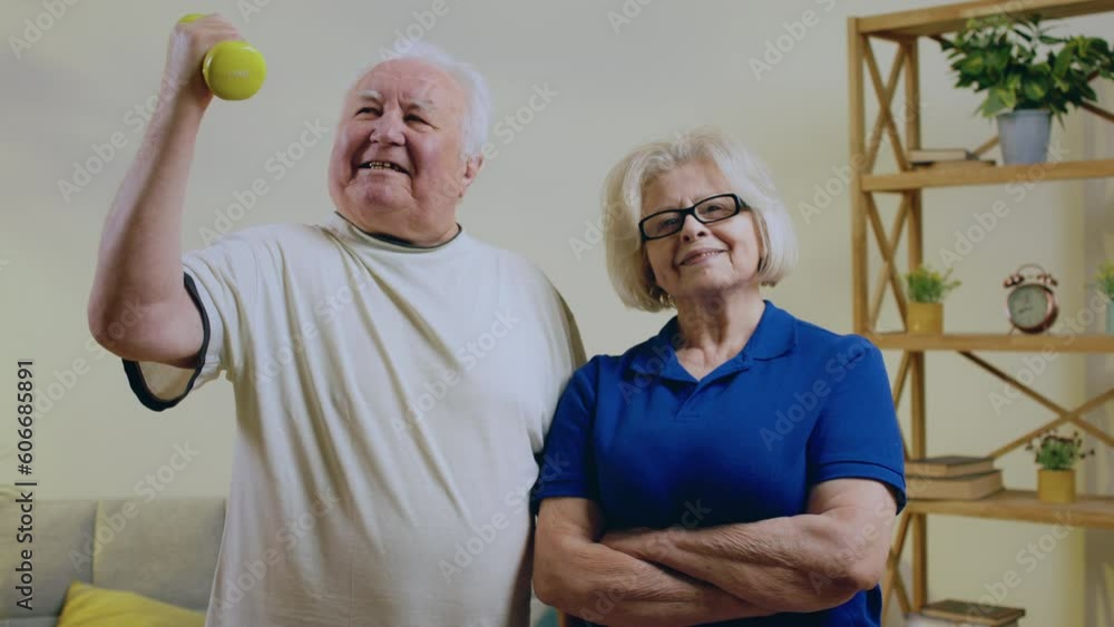 Posing in front of the camera old woman and man very charismatic and pretty man holding the weight in his hand and they are very excited Posing in front of the camera old woman and man very charismatic and pretty man holding the weight in his hand and they are very excited