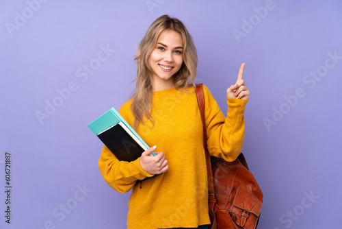 Teenager Russian student girl isolated on purple background showing and lifting a finger in sign of the best