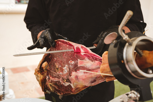 Professional ham carver cutting cured ham slices. Spanish iberian ham.