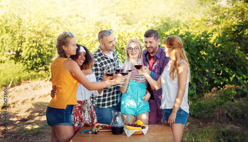 Group of Six Enjoying Wine Tour, Toasting and Tasting Red Wine amidst Lush Vineyards. Cheers to Wine and Embracing the Harvest