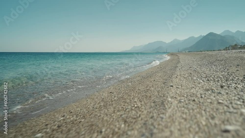 slow motion footage tropical island and sea waves crashing and foaming against pebble rocky beach. rocks coast meeting deep blue ocean water. Tourism in Turkey concept photo