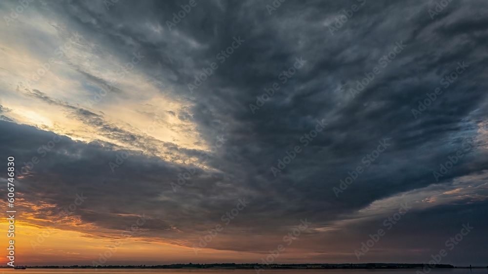 Faro island with dramatic sunset sky with gloomy clouds visible from Stubbekobing in Denmark. Faro island with dramatic sunset sky with gloomy clouds visible from Stubbekobing in Denmark.