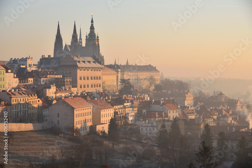Prague Castle and St. Vitus Cathedral in Prague, Czech Republic. Early morning. Orange sunrise. Winter. Haze. View from Strahov Monastery.