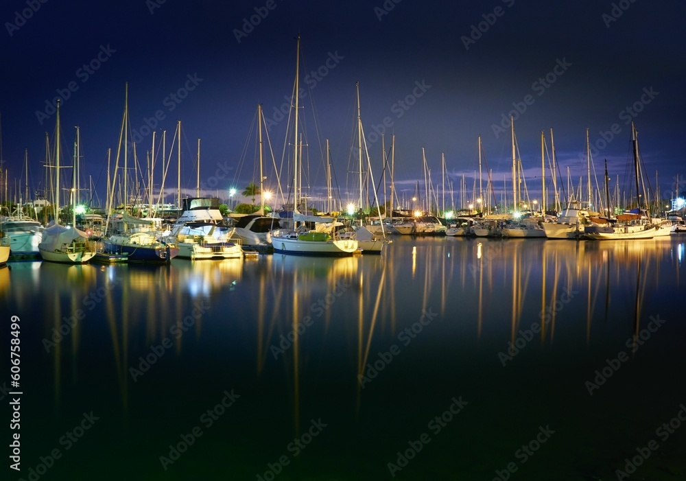 Dramatic view of the illuminated yachts parked at the Manly Marina harbor at night