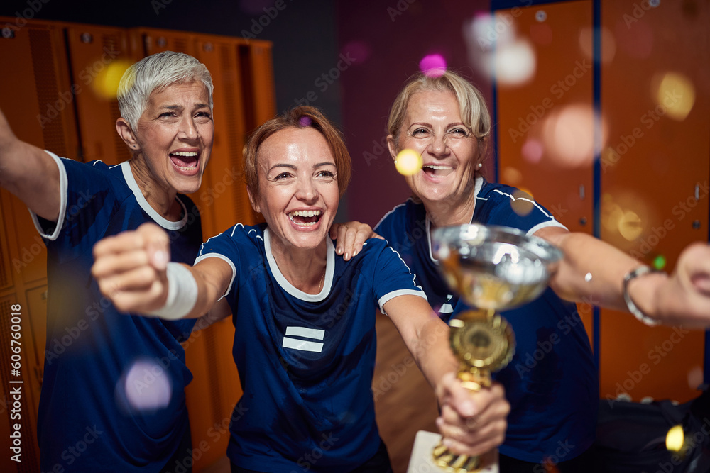Φωτογραφία Team of mature women and young trainer in sportswaer uniform winning golden cup