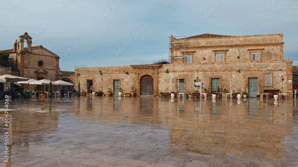 Marzamemi main square with restaurant and church after rain