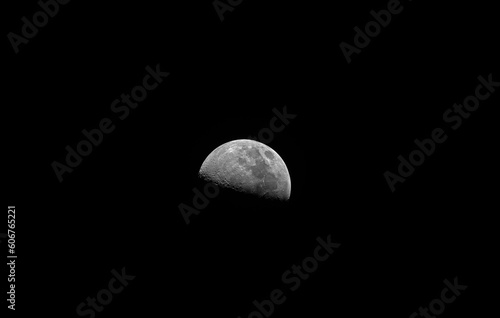 First quarter Moon phase, a large field of view, taken with refractor telescope, isolated in a black bacgound without stars.