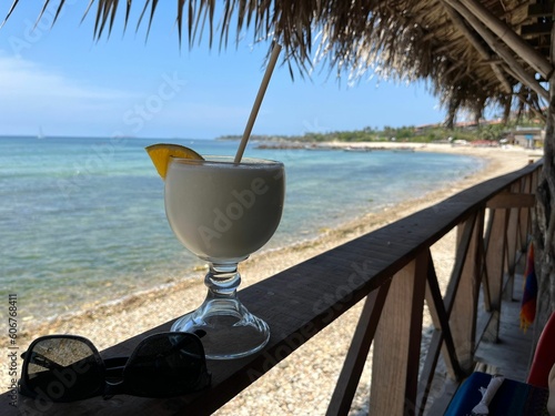 Fototapeta Naklejka Na Ścianę i Meble -  Pina colada beverage in restaurant by the ocean and beach in Mexico Vacation Holyday
