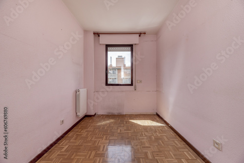 An empty room with a small red anodized aluminum window