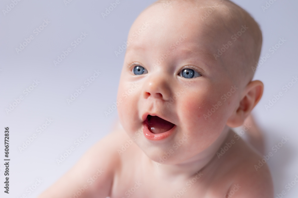 portrait of a cute baby 5 months old on a white background in the studio, smiling looking into the frame. Baby's health, newborn baby, space for text portrait of a cute baby 5 months old on a white background in the studio, smiling looking into the frame. Baby's health, newborn baby, space for text