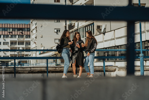 Three lovely girls checking their phones while having a conversation