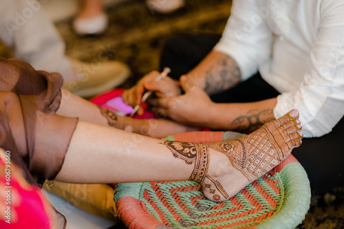 Artist applying henna tattoo on women . Mehndi is traditional Indian decorative art. Close-up