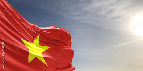 Vietnam national flag cloth fabric waving on beautiful grey sky Background.
