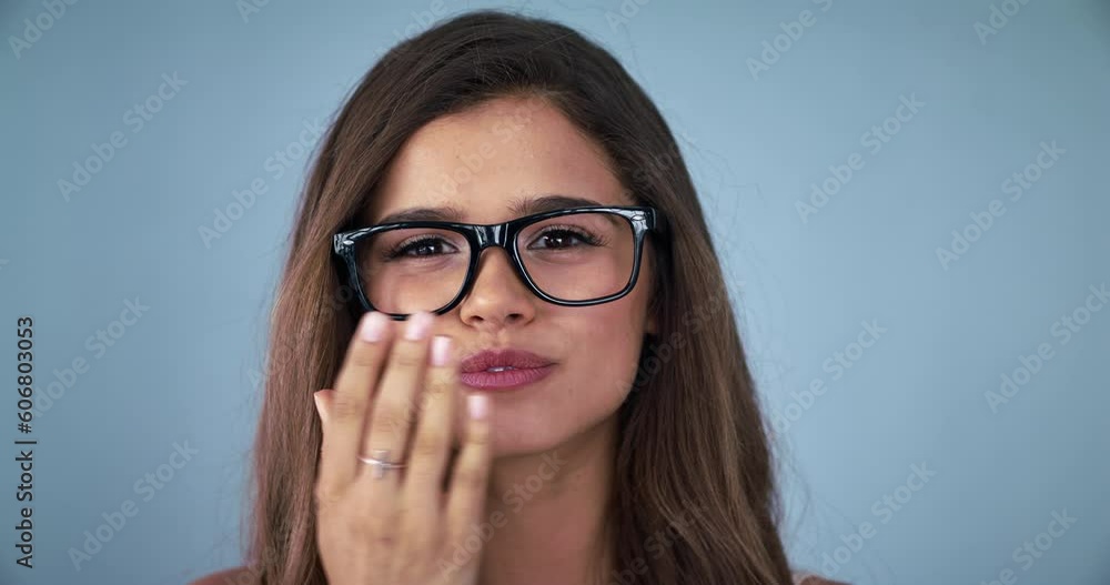 Kiss, glasses and wink with face of woman in studio for vision, flirting and eye health. Smile, happiness and beauty with portrait of model isolated on blue background for mockup, happy and emotion Kiss, glasses and wink with face of woman in studio for vision, flirting and eye health. Smile, happiness and beauty with portrait of model isolated on blue background for mockup, happy and emotion
