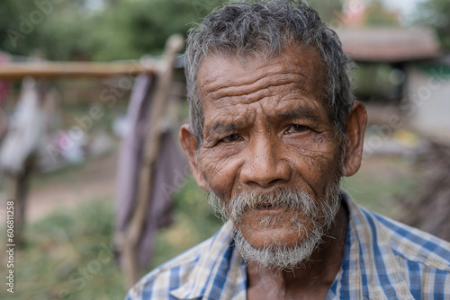  Asian man which is a poor lonely elderly farmer and employee in the rural farm. live in a small shabby old house. photo