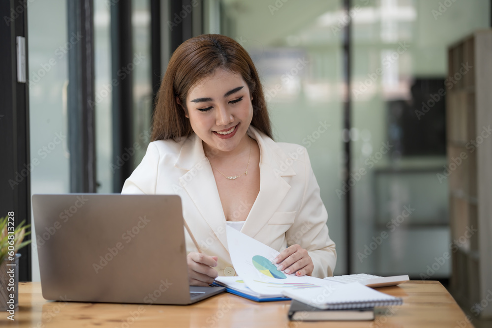 Asian Businesswoman working on a laptop at her desk at the office. Asian Businesswoman working on a laptop at her desk at the office.