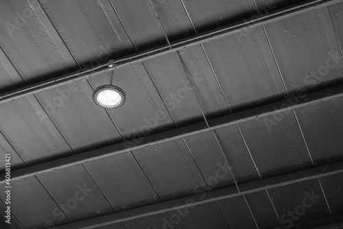 Bilde på lerret LED floodlight lamp on black metal ceiling on the factory warehouse place