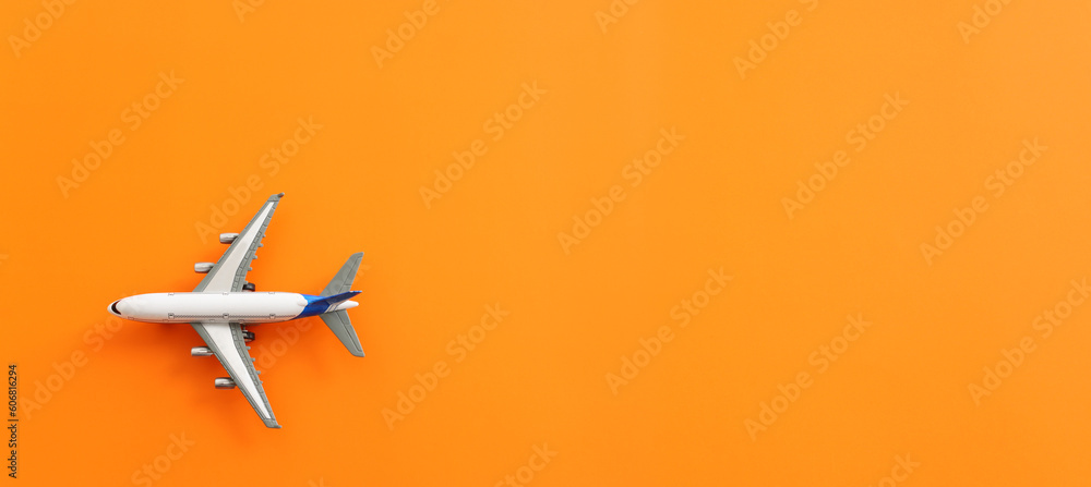 Top view of orange background and airplane. Concept of travel, vacation