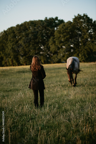 girl with a horse is standing in the field © Roman