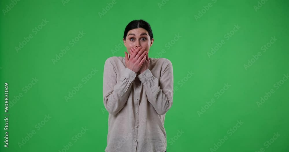 Caucasian woman on green screen background looking at the camera. Suddenly, she sees something amazing and exclaims Wow with a big smile and laughter and cover her mouth with her hands. Caucasian woman on green screen background looking at the camera. Suddenly, she sees something amazing and exclaims Wow with a big smile and laughter and cover her mouth with her hands.