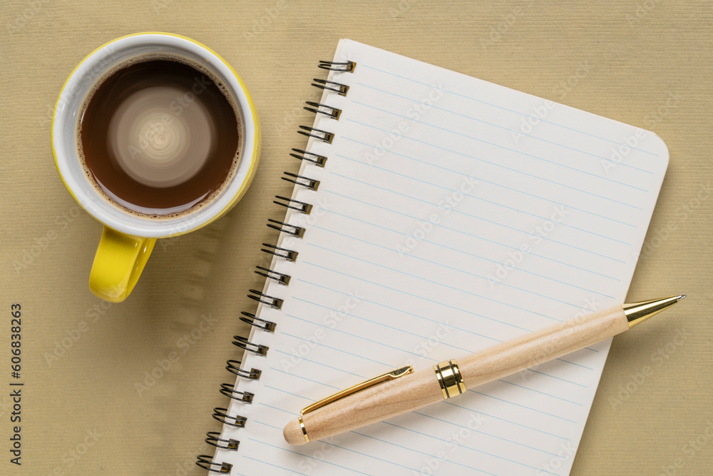 blank spiral sketchbook against textured paper with a cup of coffee, desktop flat lay blank spiral sketchbook against textured paper with a cup of coffee, desktop flat lay