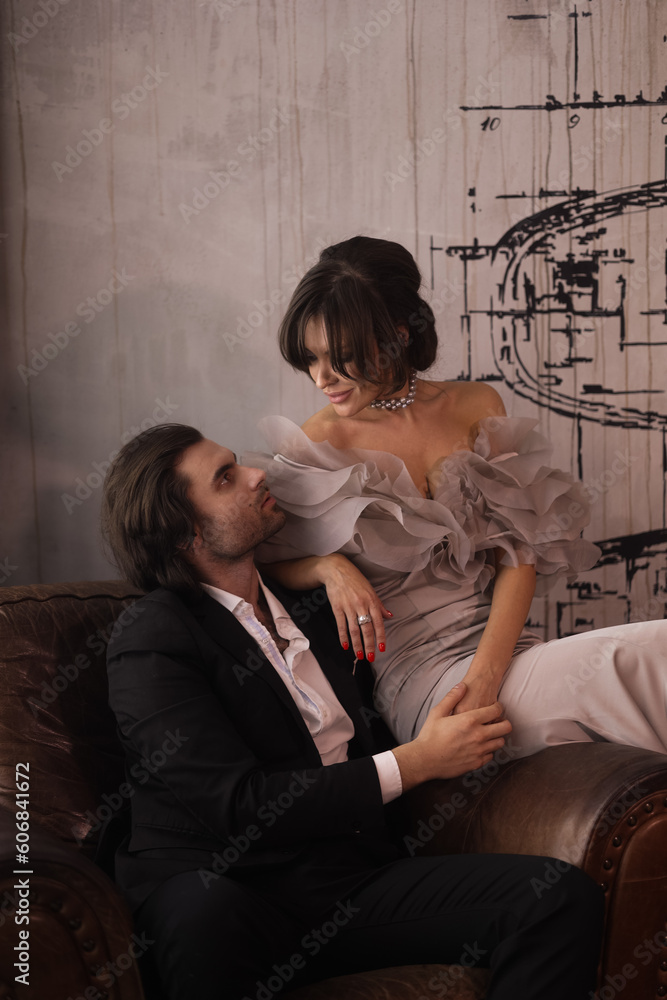Naklejka premium Gorgeous beautiful woman with a man touching each other. A lovely couple dressed in evening clothes. Wife and husband embrace and kiss passionately