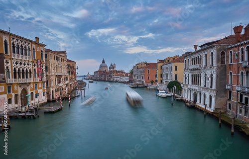 Old canal with bridge, gondola, houses, flowers in cloudy weather. Venice © Ryzhkov Oleksandr