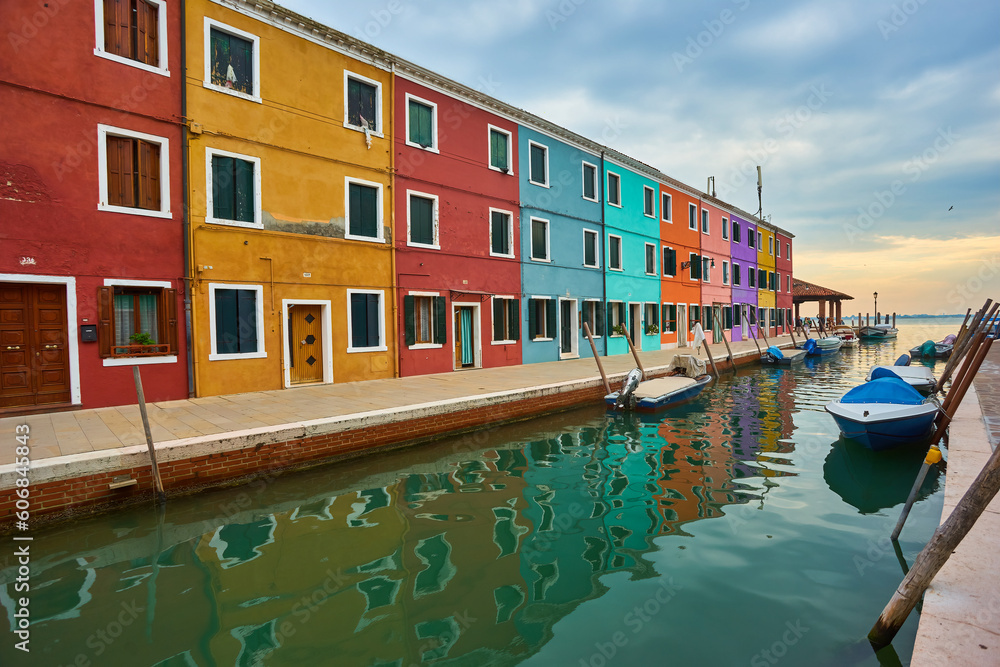 Colorful architecture and canal with boats in Burano island, Venice, Italy. Famous travel destination.