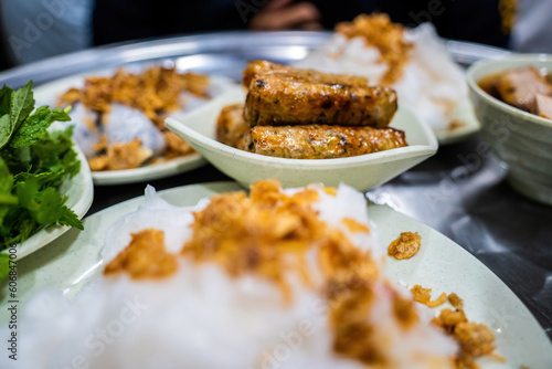 Banh cuon - Vietnamese steamed rice rolls with minced meat inside accompanied by bowl of fish sauce. Detail.