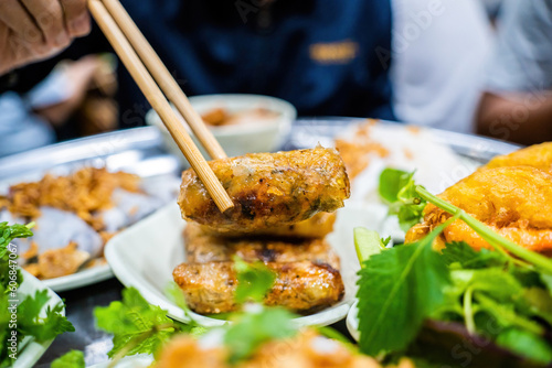 Banh cuon - Vietnamese steamed rice rolls with minced meat inside accompanied by bowl of fish sauce. Detail. photo