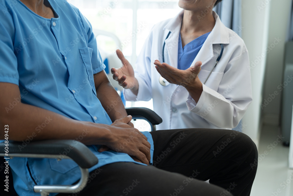 Friendly Male Doctor Talks to Male Patient. doctor with chart attending sick man in hospital ward. Friendly Male Doctor Talks to Male Patient. doctor with chart attending sick man in hospital ward.
